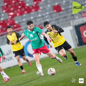 شعار نادي الحسين إربد ونادي الوحدات مع حكام كرة قدم في خلفية ضبابية.