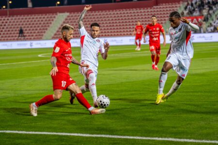 شعار نادي الجزيرة مع حكم كرة قدم يشير بيده